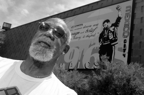 John Carlos, participant of the 1968 Olympics, stands in front of a mural made by students on the campus, at Palm Springs High School